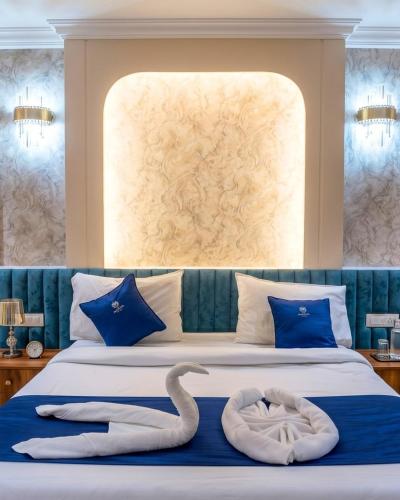 a bedroom with two swans on a bed at THE MASARA MANAR Hotel in Gwalior
