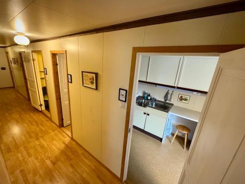a room with a kitchen with a counter and a hallway at Lofoten Light - Private Rooms with Shared Facilities in Gravdal