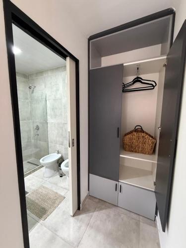 a bathroom with a walk in shower and a toilet at Botanic Apart in Villa María