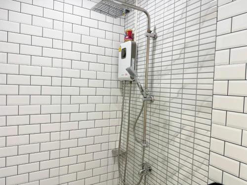 a shower in a bathroom with white tiled walls at Areeya Khao Khad Aoyon Beach in Ban Ao Makham