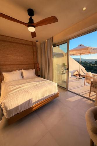 a bedroom with a bed and a balcony at Akres Luxury Sea View Villas in Psalidi