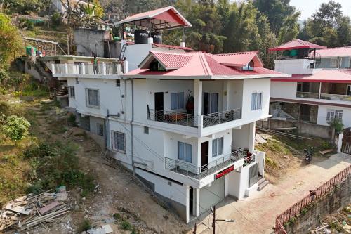 an overhead view of a white building with a red roof at Magpie Residency Kalimpong in Kalimpong