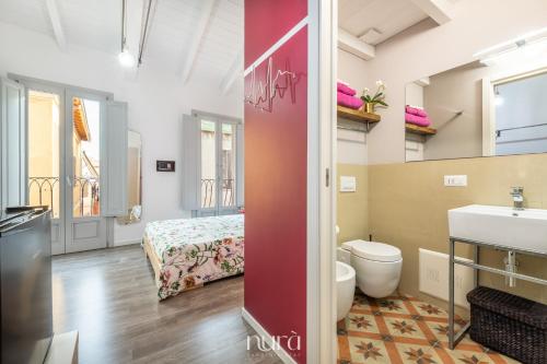 a bathroom with a toilet and a sink and a bed at Wine Passion Room in Quartu SantʼElena