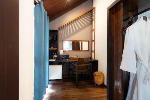 a hallway with a room with a desk and a table at Sanctuary Hotel Luang Prabang in Luang Prabang