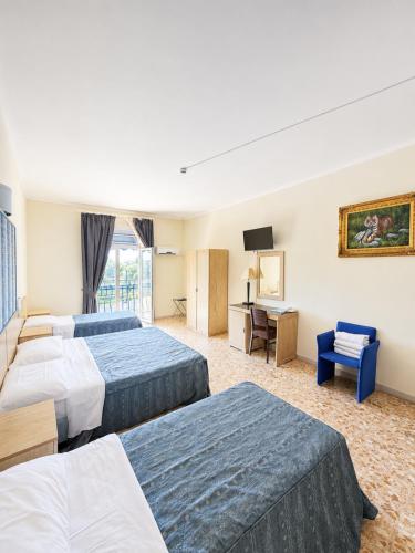 a hotel room with two beds and a desk at Hotel Chopin in Fiumicino