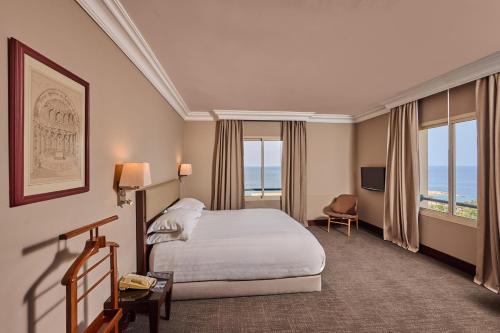 a hotel room with a bed and a television at Portemilio Hotel & Resort in Jounieh