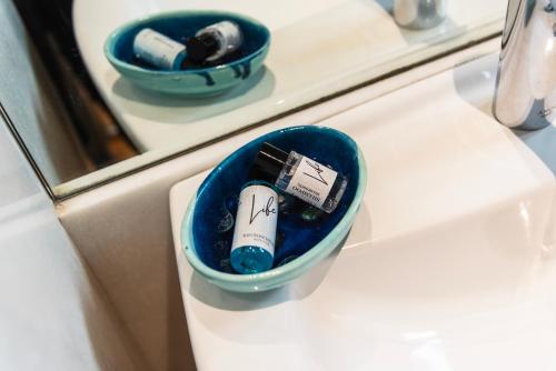 a blue container sitting on a counter with toothbrushes in it at Youhosty - Duomo Studio Apartment in Milan