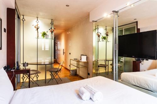 a hotel room with a bed and a flat screen tv at Youhosty - Duomo Studio Apartment in Milan