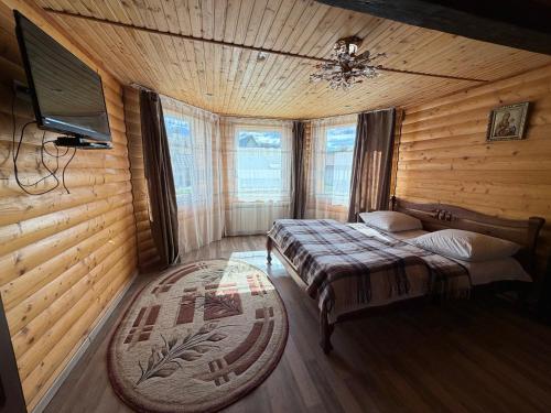 a bedroom with two beds and a flat screen tv at Sadyba u Anastasijky in Synevyr