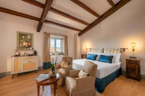 a bedroom with a king sized bed and a couch at Borgo Tre Vaselle in Torgiano