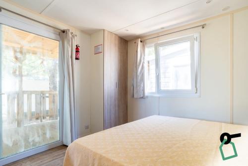 a bedroom with a bed and a large window at Hotiday Montalto Marina in Torre di Montalto