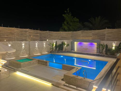 a swimming pool in a backyard at night at Krir city villa in Alexandria
