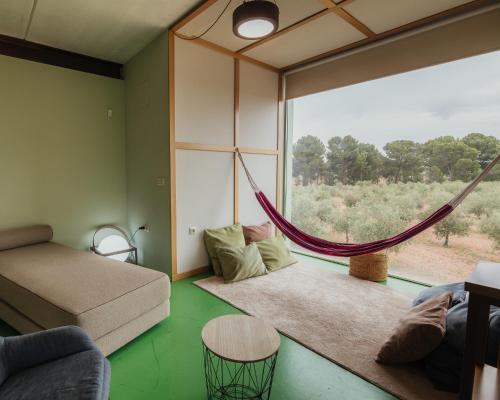 a living room with a hammock and a large window at Luz de Alba in Argamasilla de Alba