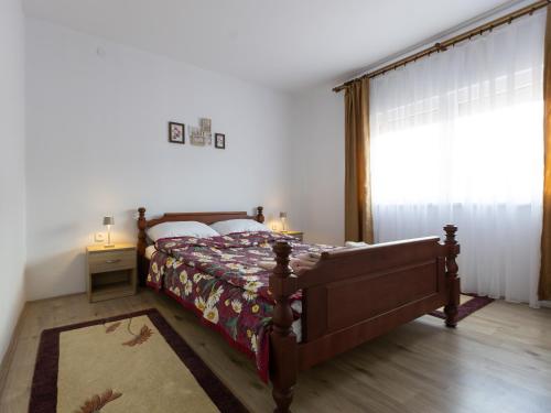 a bedroom with a bed and a large window at Apartman Mila Raška in Raška