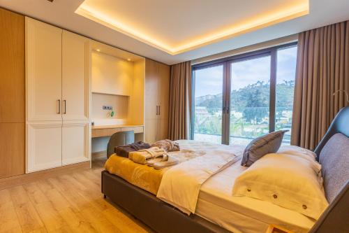 a bedroom with a large bed with a large window at Leaf Villa Terra in Antalya