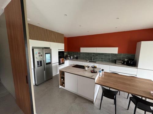 a kitchen with white cabinets and a wooden table at Villa à Lux in Lux