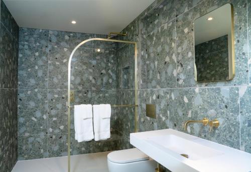 a bathroom with a sink and a toilet and a mirror at THE NICI Newquay in Newquay