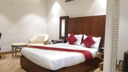 a bedroom with a large bed with red pillows at hotel sunfire in Chhindwāra