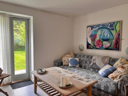 a living room with a couch and a table at Fred og Ro Ferielejlighed in Ulstrup