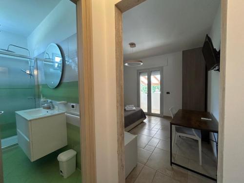 a bathroom with a sink and a toilet and a mirror at A casa di Raf in Torre Lapillo