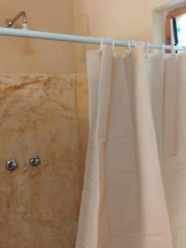 a shower curtain is hanging in a bathroom at 1, 2 bed bungalow Watamu in Watamu