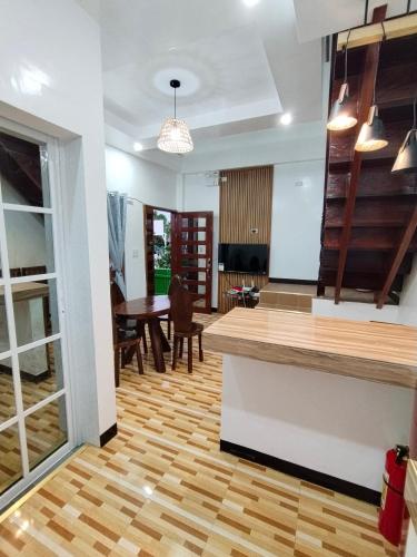 a kitchen and dining room with a wooden floor at Felrita Homestay in Alegria