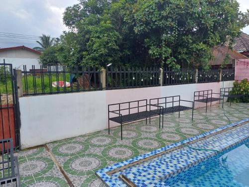 a swimming pool with a fence next to a fenceasteryasteryasteryasteryasteryastery at The Big Brother Mouse Hostel in Vang Vieng