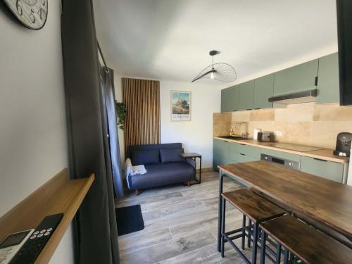 a kitchen and a living room with a blue couch at Une escapade en Provence in Pertuis