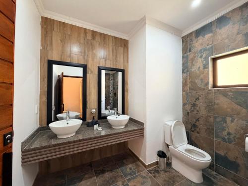 a bathroom with two sinks and a toilet at Mvubu Falls Lodge in Lobamba