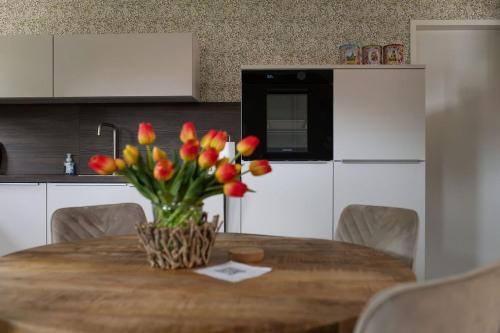 a kitchen table with a vase of flowers on it at Hannes in Schagen