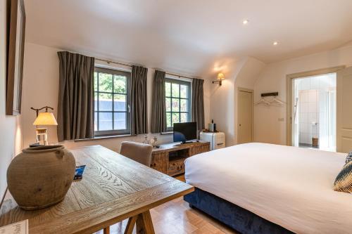 a bedroom with a large bed and a desk with a computer at Villa Magdalena Eeklo in Eeklo