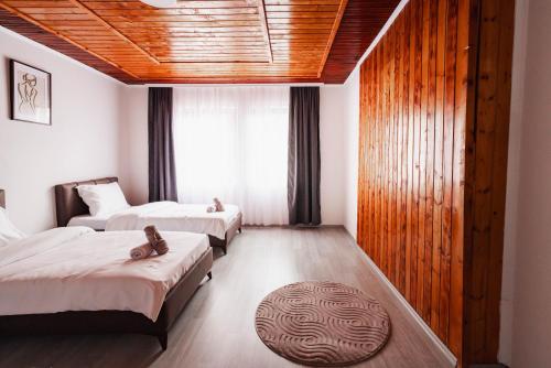 a hotel room with two beds and a rug at Dea Apartments - Peja in Peje