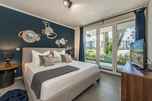 a bedroom with a bed and a large window at Terrasse am Haff in Zirchow