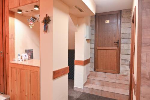 ein Flur mit Tür und Treppe in einem Haus in der Unterkunft Кирицова Къща in Bansko