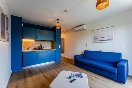 a living room with a blue couch and a table at Studio for 2 in La Teste-de-Buch parking in La Teste-de-Buch