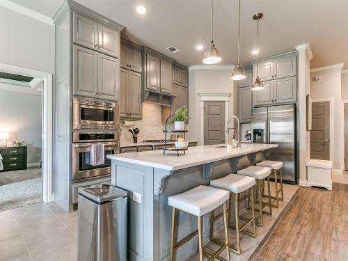 a kitchen with a large island with bar stools at Exquisite Escape in Moore! in Moore