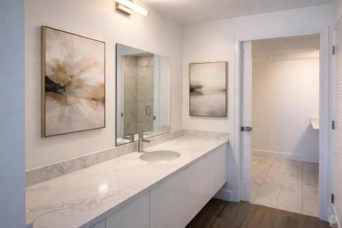 a white bathroom with a sink and a mirror at CW Hotel in Clearwater Beach
