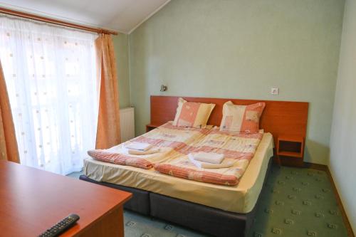 ein Schlafzimmer mit Bett, Schreibtisch und Fenster in der Unterkunft Кирицова Къща in Bansko