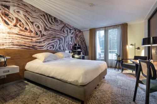a bedroom with a large bed with a wall mural at Hotel Woudschoten in Zeist