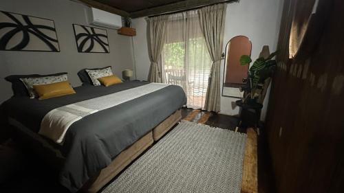 a bedroom with a large bed and a window at Ghxabara Cozy Cabin in Maun