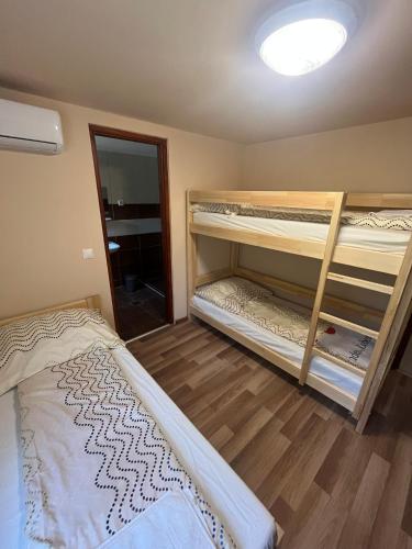 a bedroom with two bunk beds and a mirror at Strand Motel, Vígadó Csárda in Dombrád