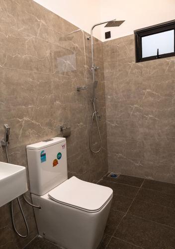 a bathroom with a toilet and a shower at Port Royal Residence in Trincomalee