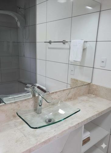a bathroom counter with a sink and a mirror at Chalé Vale Carahá Hortensia in Gramado