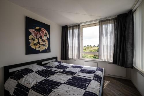 a bedroom with a bed and a window at Penthouse Ostrea 60 in Nes