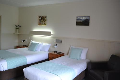 a hotel room with two beds and two lamps at Gatton Motel in Gatton