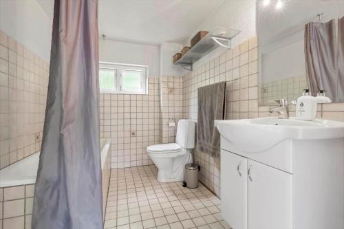 a white bathroom with a sink and a toilet at 20335-Samso-Marsk-Stigs-vej-4 in Tranebjerg