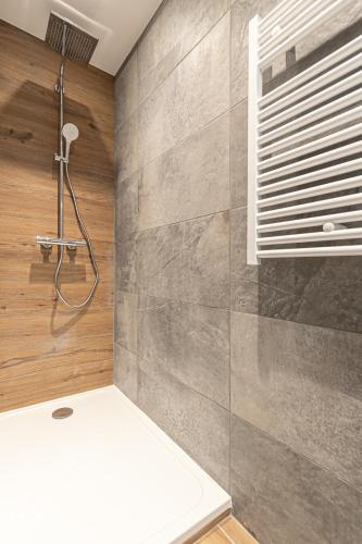 a bathroom with a shower and a wall at ALPINA LODGE VANOISE ex hotel du soleil in Aussois