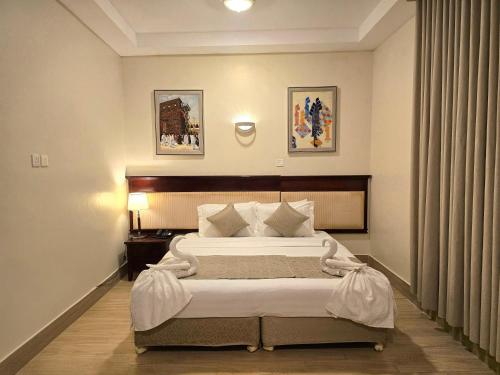 a bedroom with a large bed in a room at Midhal Al Ezz Ajyad Hotelفندق مدهال العز in Mecca