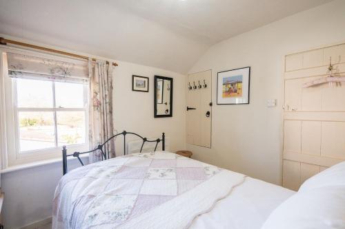 a bedroom with a bed and a window at Fishermans Cottage, Aldeburgh in Aldeburgh
