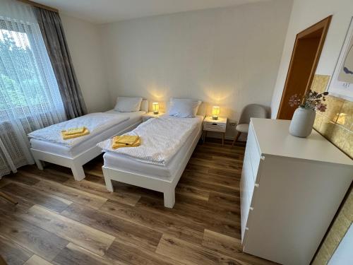 two beds in a small room with two lamps at Pension Katharina im Solling in Holzminden